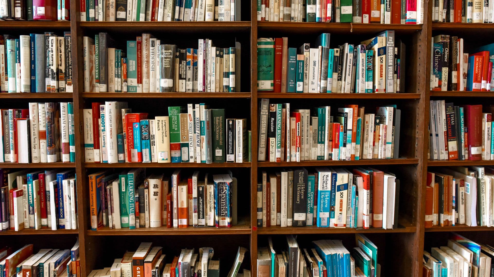 Open book resting on a dark polished wooden desk